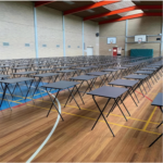 Rows of Fold exam tables set up across a school gymnasium for exams